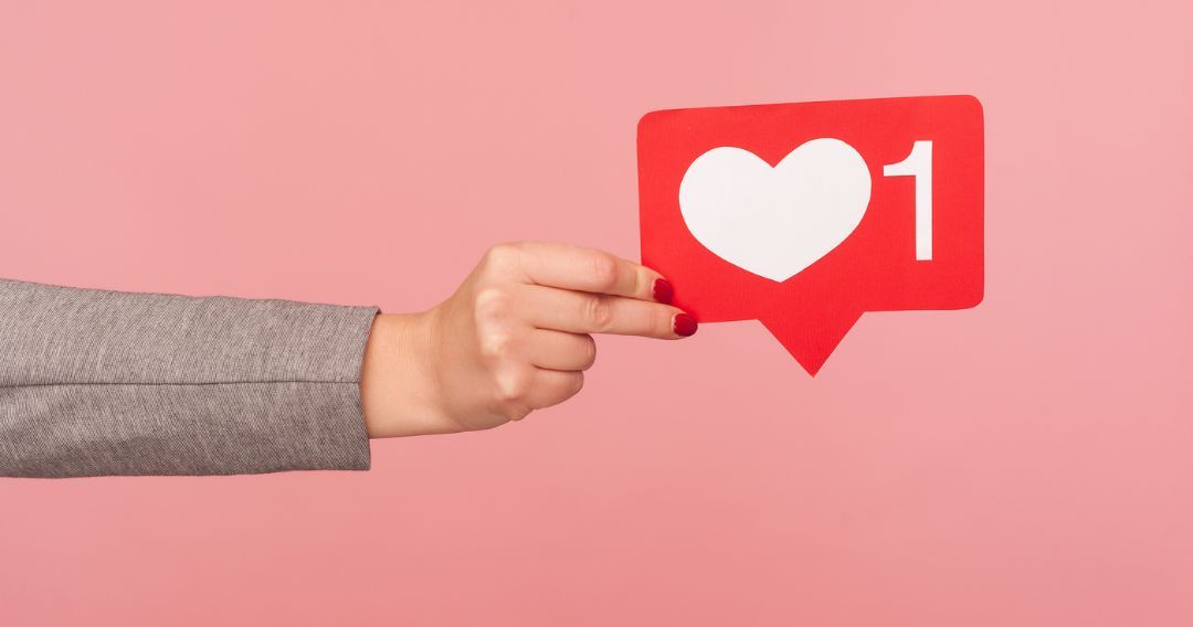 A woman holding a heart engagement symbol